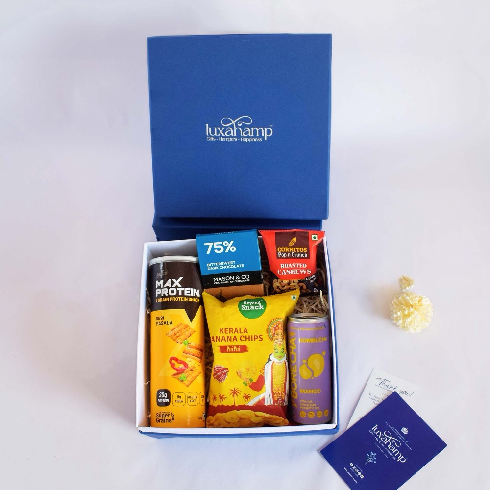 A Gourmet Wellness Delight hamper in its navy LuxaHamp box, lid standing behind and a gift card beside it