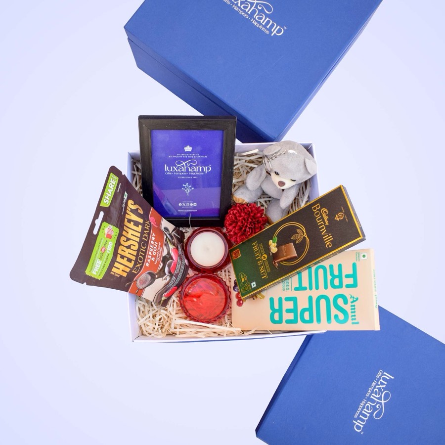 Open LuxaHamp gift box with chocolates, a candle and treats